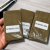 La Mousse (NVE) Hash packages in clear sealed wrapping with white product labels arranged on a light wood surface