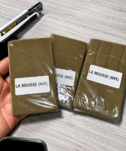 La Mousse (NVE) Hash packages in clear sealed wrapping with white product labels arranged on a light wood surface